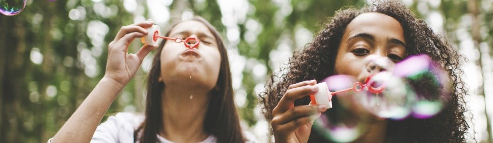 two girls blowing bubbles