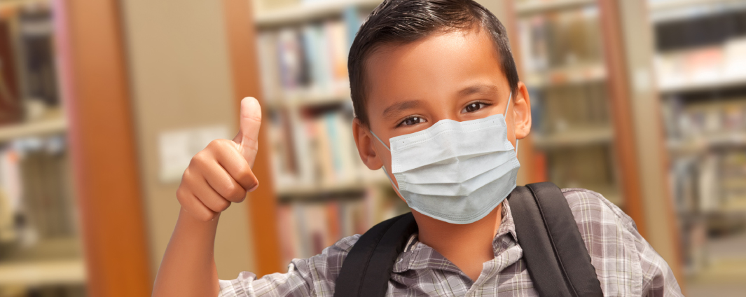 boy smiling with thumbs up, wearing mask